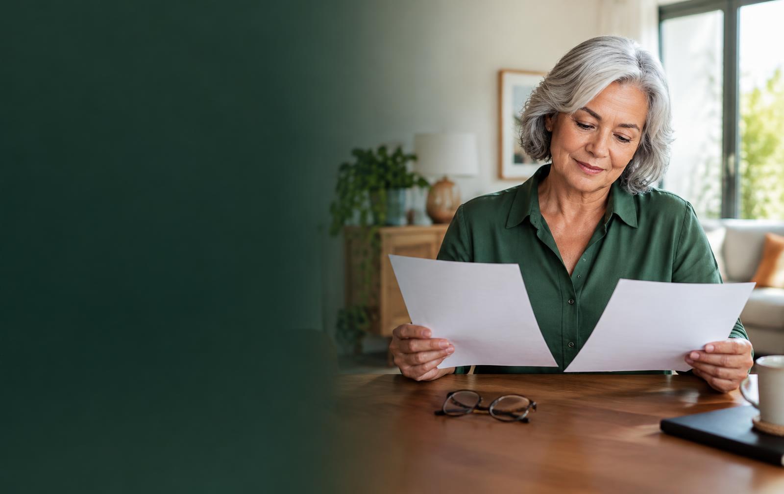 Aposentada comparando documentos de contratos em casa